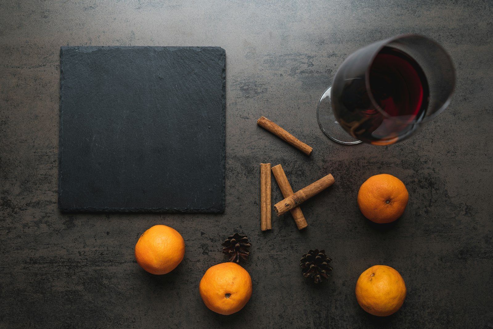 An overhead spread of winter cocktails surrounded by oranges, cinnamon sticks and star anise