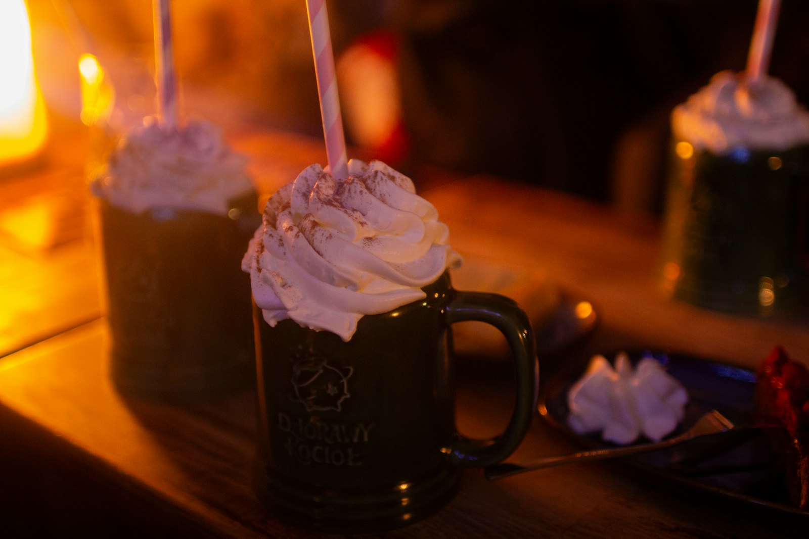 A glass of creamy eggnog dusted with nutmeg beside a whisk and eggs.
