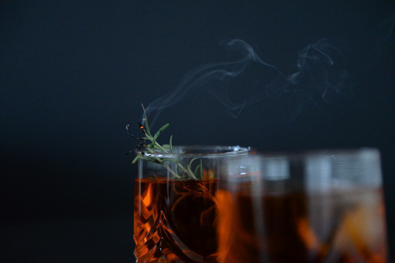 A thermometer resting in a steaming glass of spiced warm cocktail.