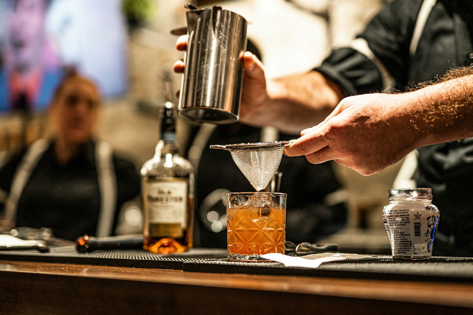A pan of spiced liquid being gently stirred on a stovetop.