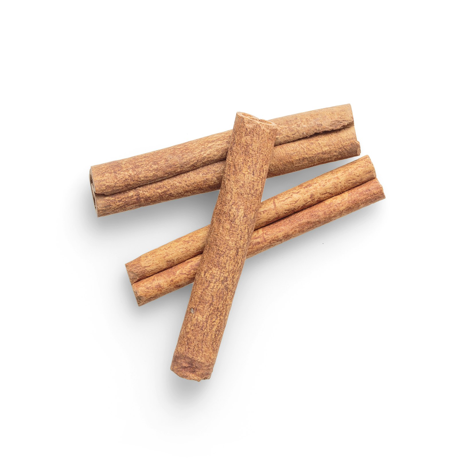 A bundle of rolled cinnamon sticks beside a small pile of ground cinnamon