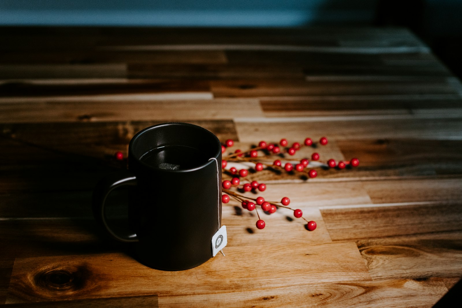 A heatproof mug of alcohol-free glögg with raisins and blanched almonds at the bottom.