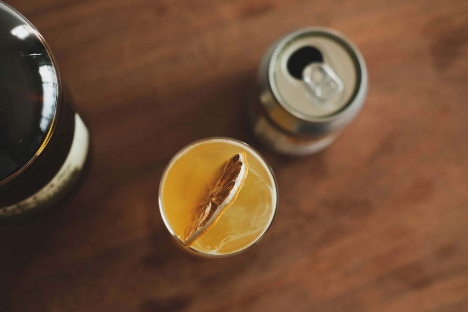An apple brandy hot toddy in a heatproof mug with a cinnamon stick and a slice of apple.