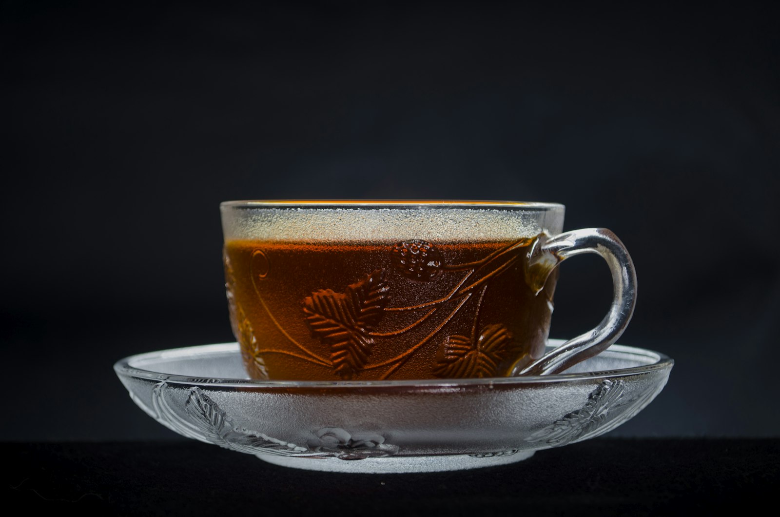 Two heatproof mugs of amber Austrian punsch garnished with orange slices and a cinnamon stick.