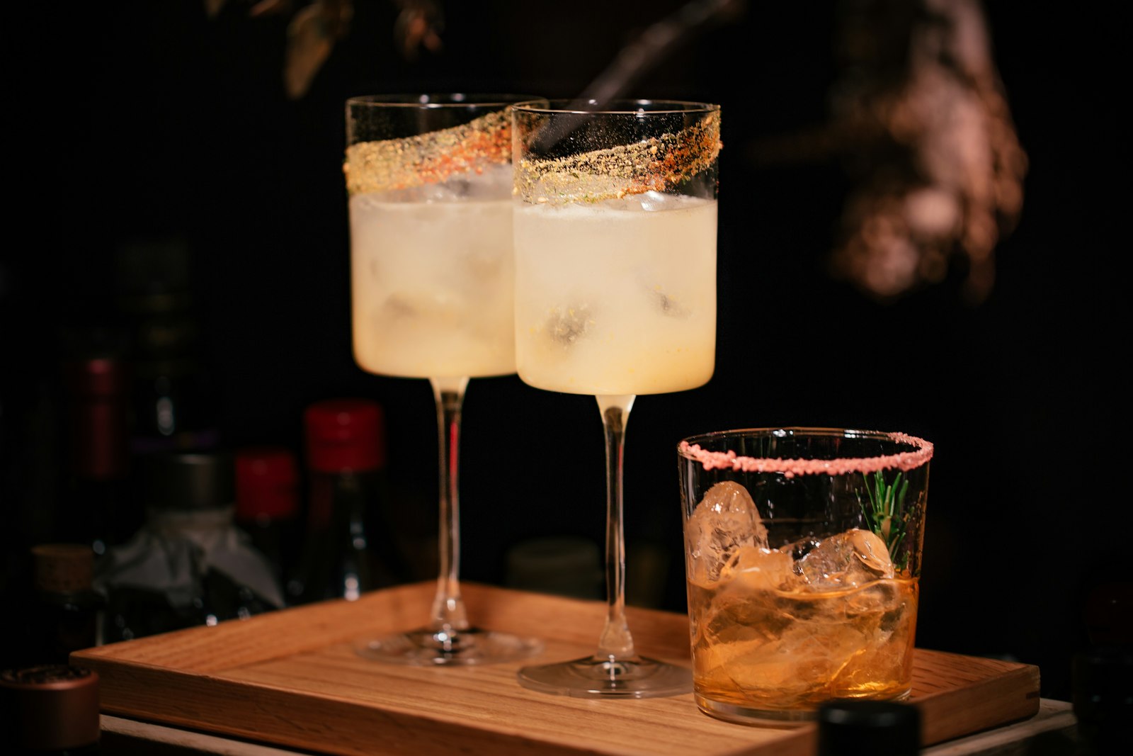 Cardamom gin fizz in a tall highball glass with lemon twist and green cardamom pod garnish, soft winter light behind.