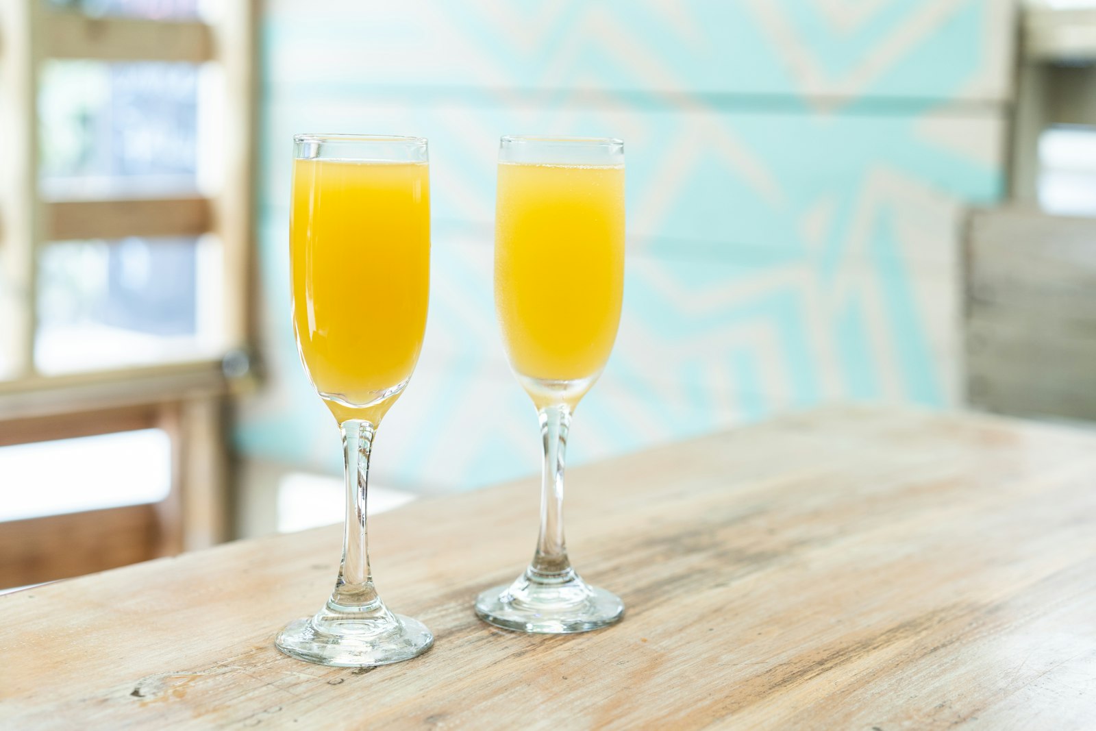 A pink Cranberry Mimosa in a champagne flute with orange peel and cranberries