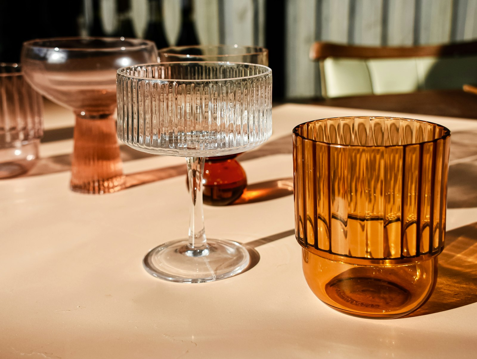 Ginger old fashioned in a rocks glass with a single large ice cube, orange peel twist and a piece of candied ginger on a pick.