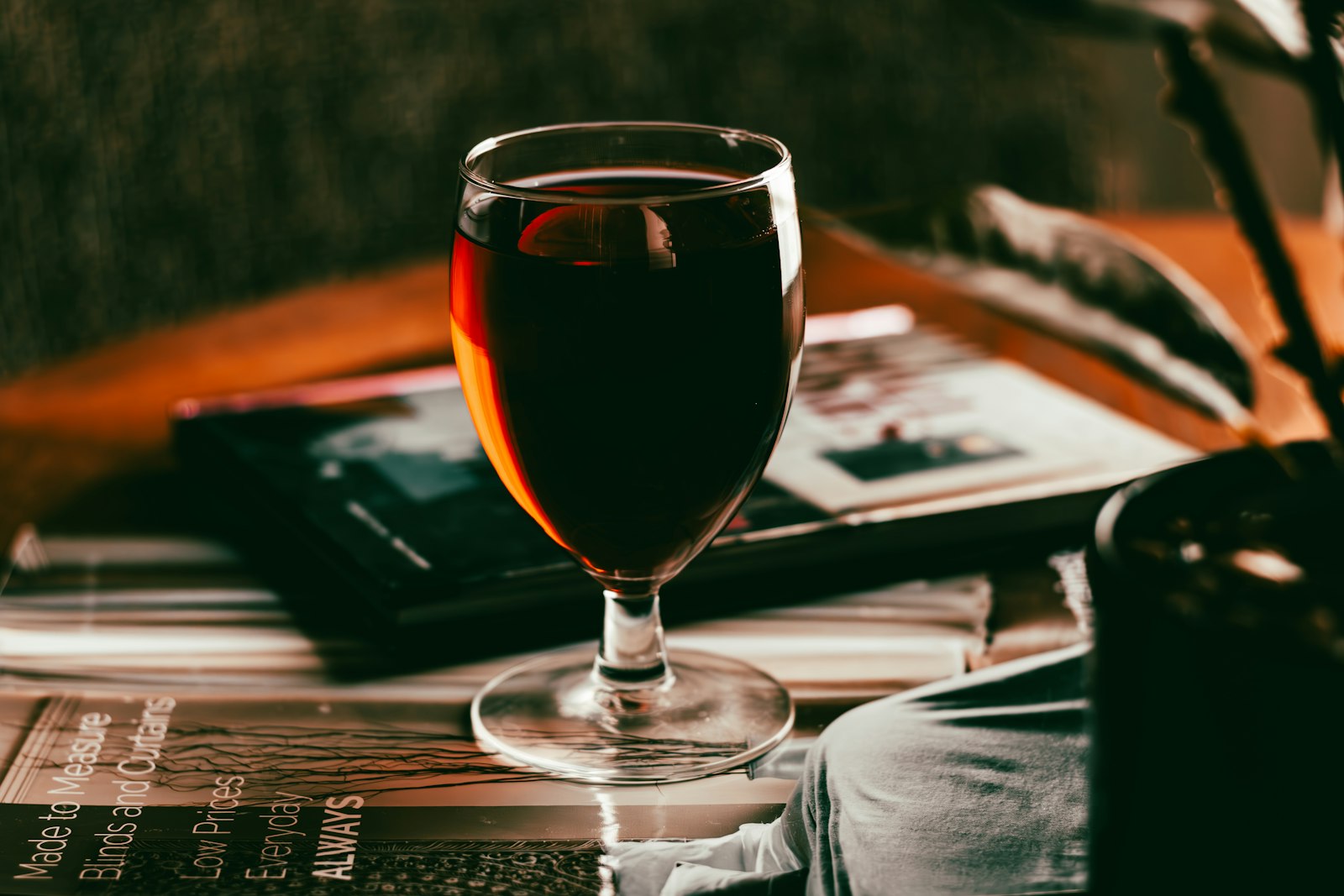 A heatproof glass of warm apple brandy with cloudy apple juice, a cinnamon stick and an apple slice.