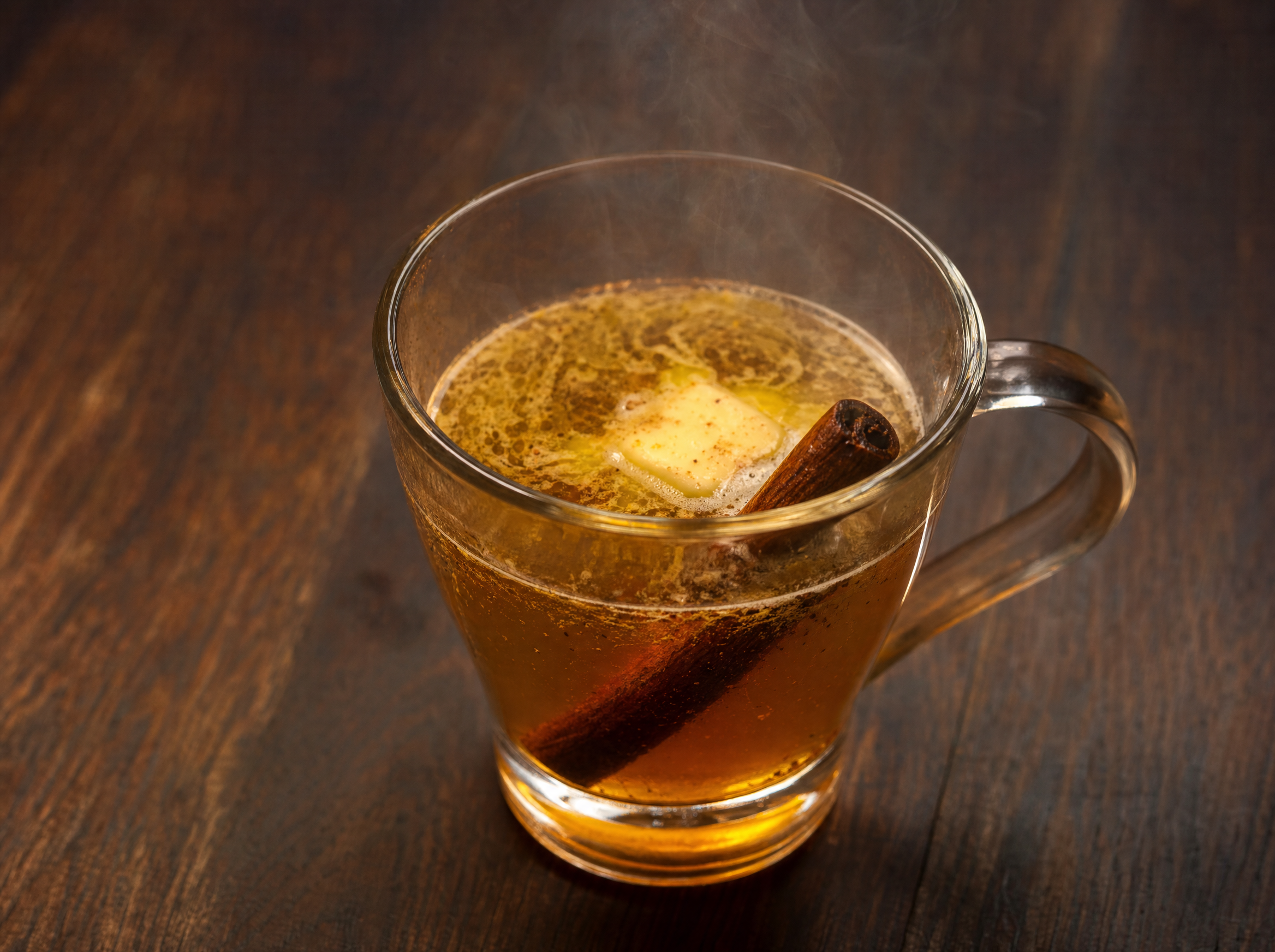 Hot buttered bourbon in a mug with melting spiced butter on top