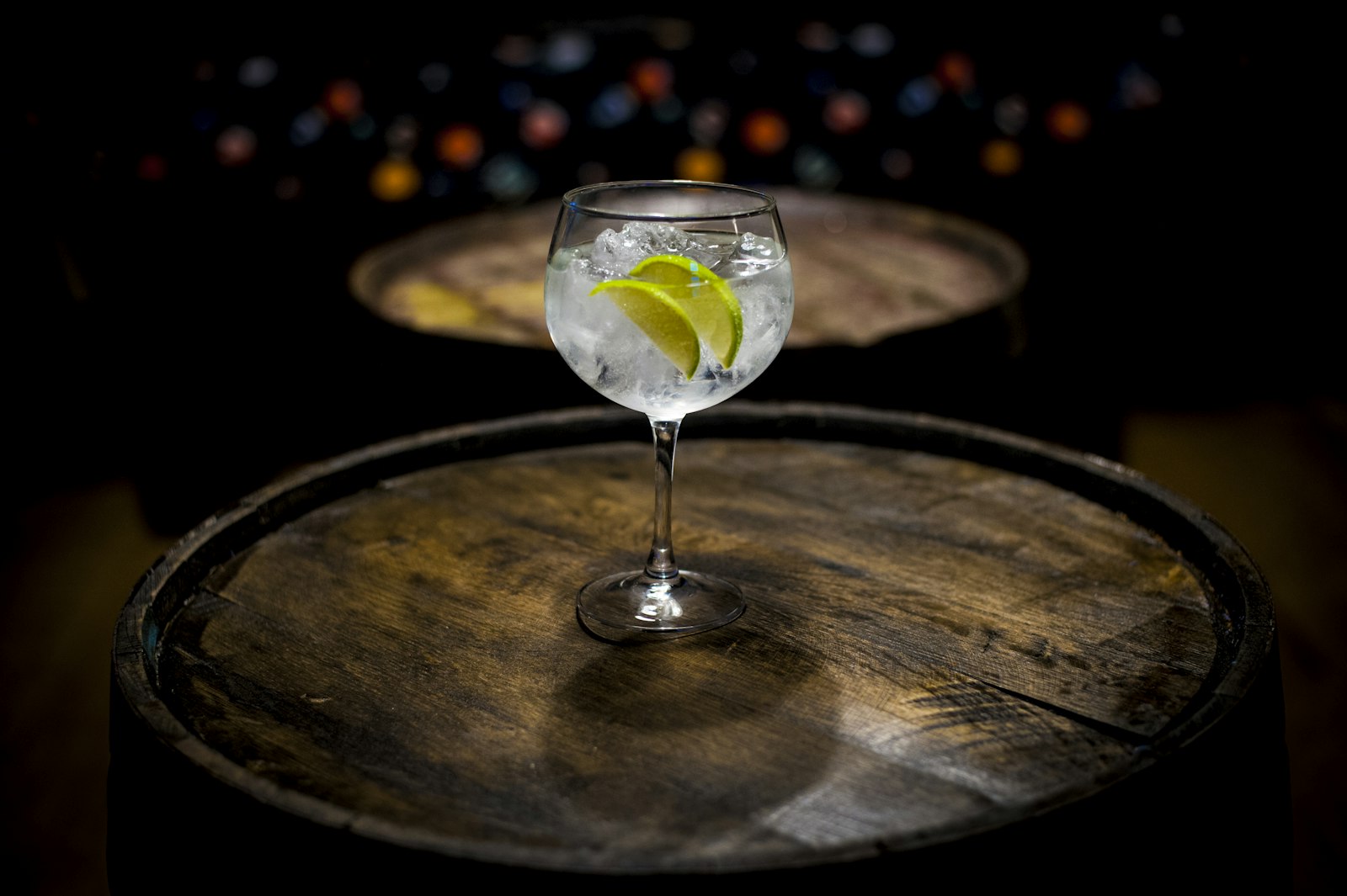 A hot gin and tonic in a heatproof mug with a rosemary sprig and juniper berries.