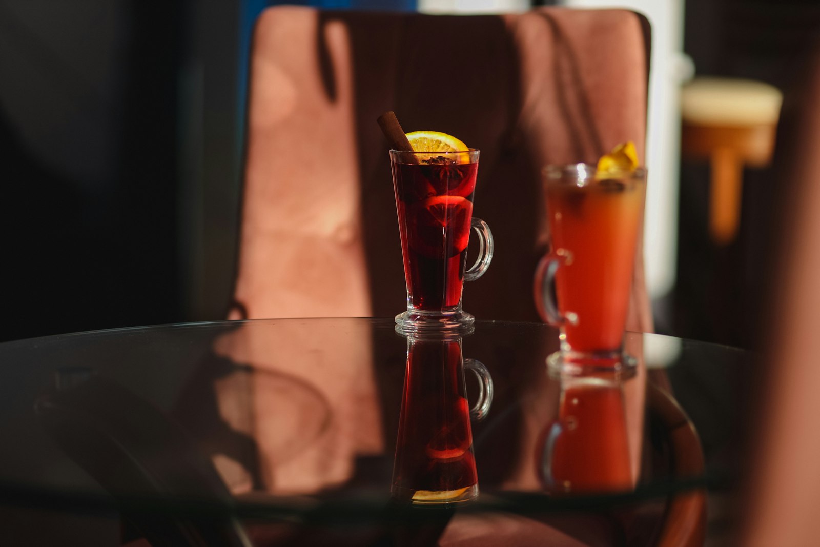 A warmed glass of amber hot gin punch with a piece of pineapple and a dusting of nutmeg.