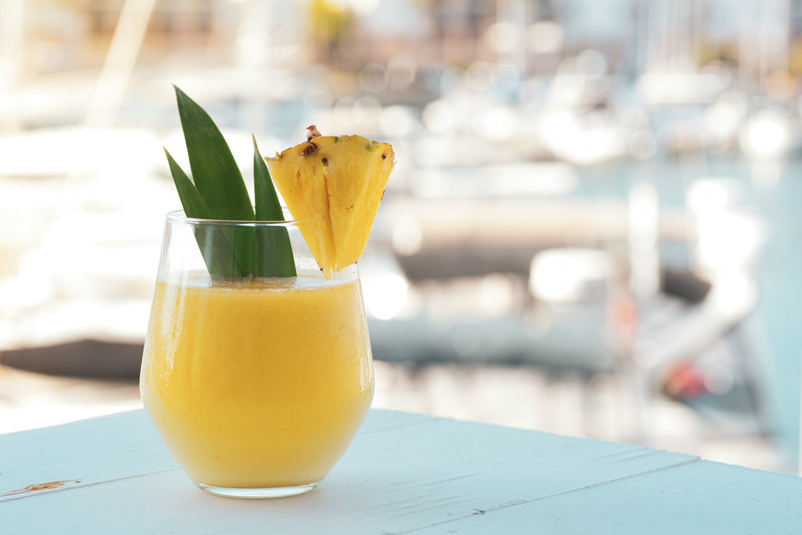 Hot mulled pineapple punch in a heatproof mug with cinnamon stick and pineapple wedge