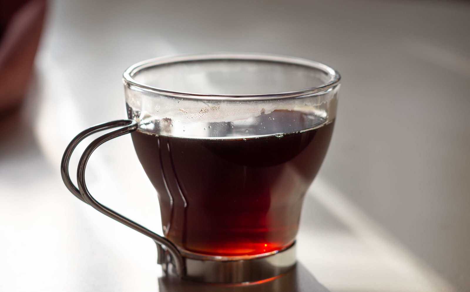 Hot spiced tea cocktail in a glass mug with orange slice and cinnamon stick