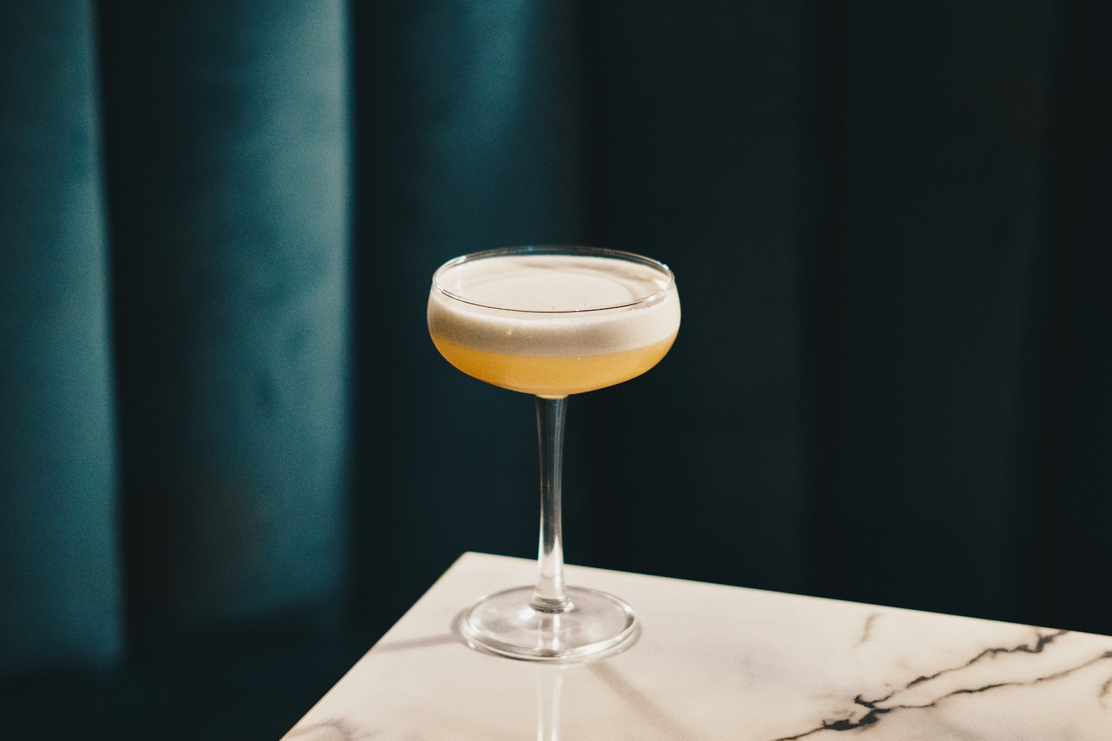 A hot whisky sour in a heatproof mug with a cinnamon stick and lemon slice.