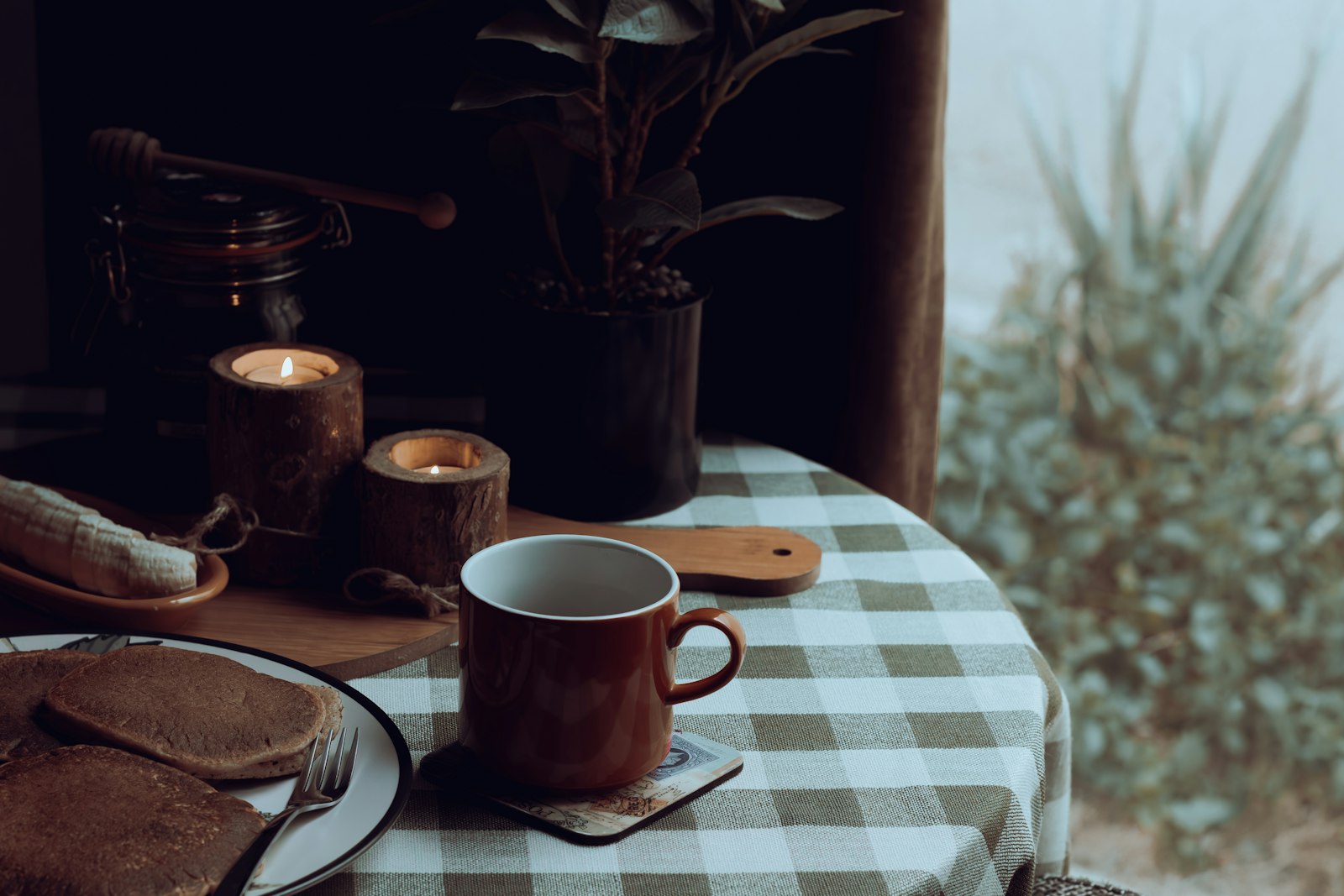 A heatproof mug of dark Austrian Jägertee with a lemon slice and cinnamon stick.