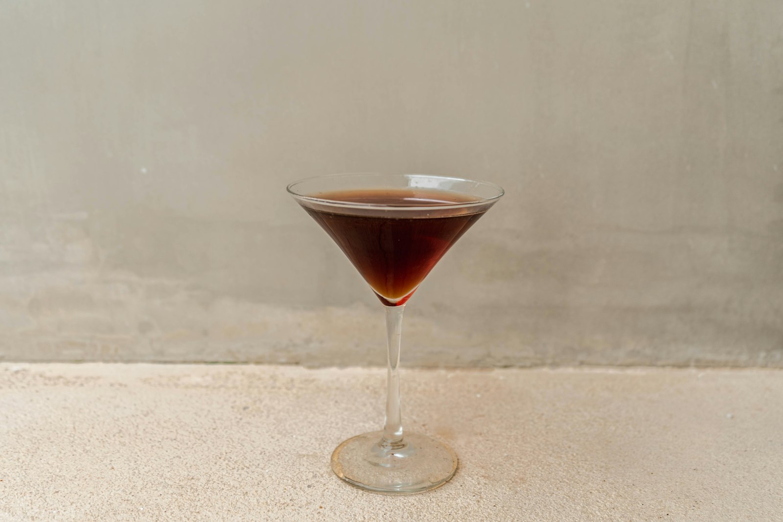 Warm Mezcal cocktail in a tumbler with floating orange wheel and faint steam