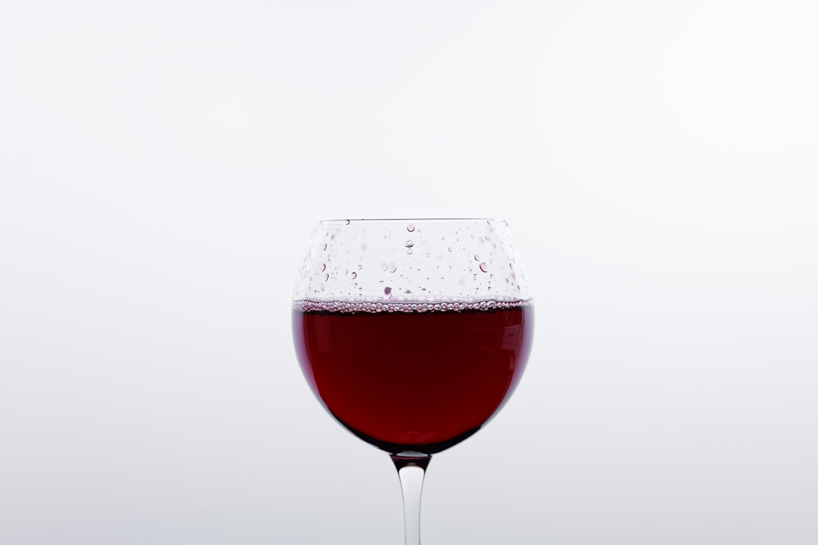 Mulled cranberry wine in a heatproof glass with floating cranberries and orange peel