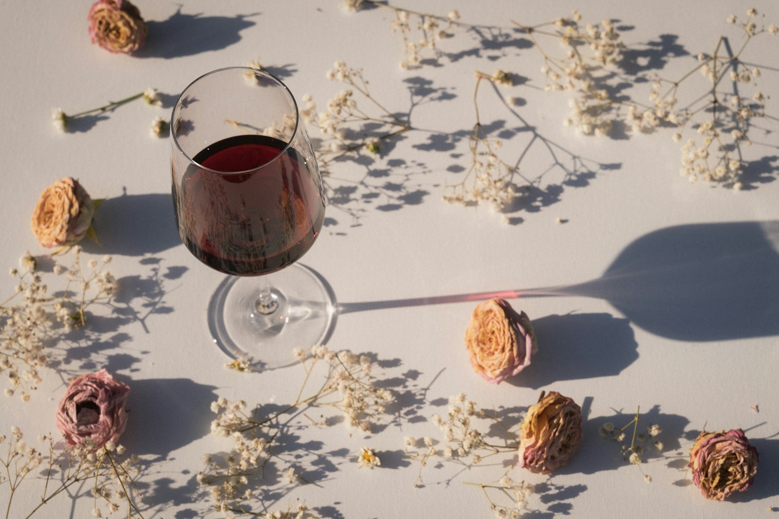 Heatproof glasses of pale pink mulled rosé wine with orange slices, star anise and a vanilla pod.