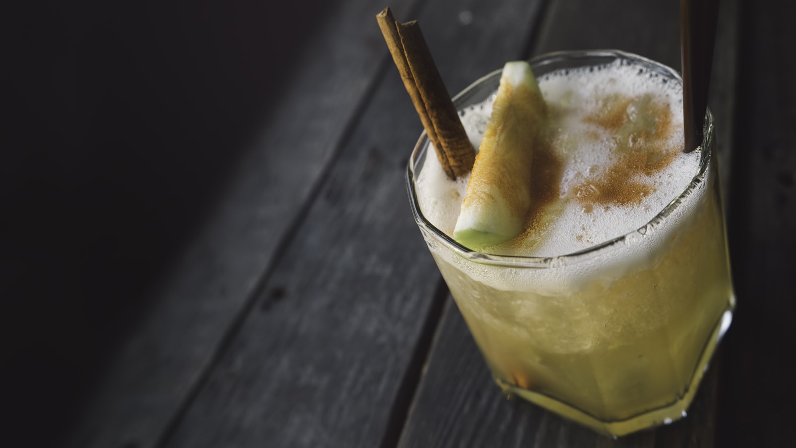 Tall glass of virgin spiced pear mocktail with fresh pear slice