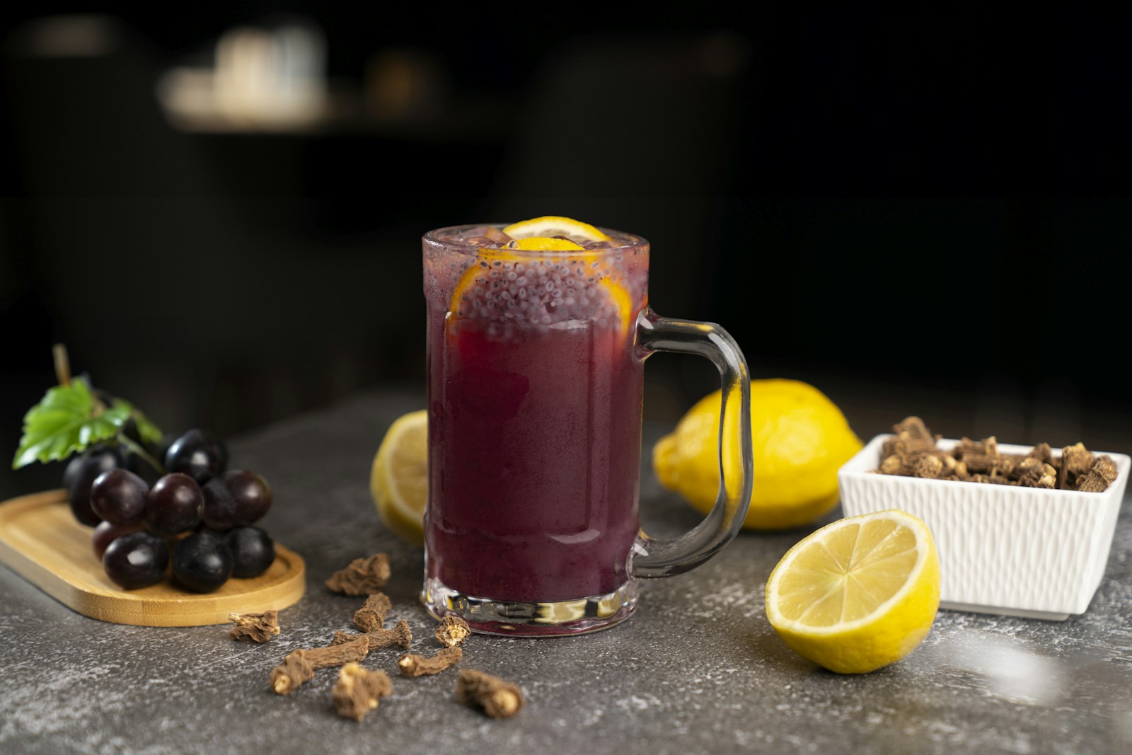 A heatproof glass of deep red virgin vin chaud garnished with an orange slice and star anise.
