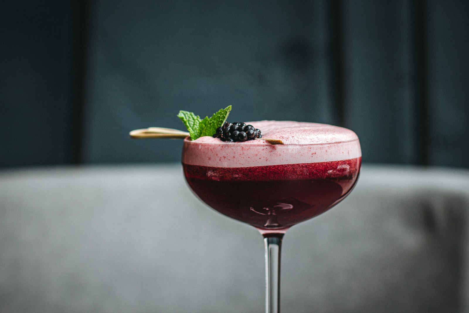 A heatproof glass of warm cranberry punch with orange slices, a cinnamon stick and star anise.