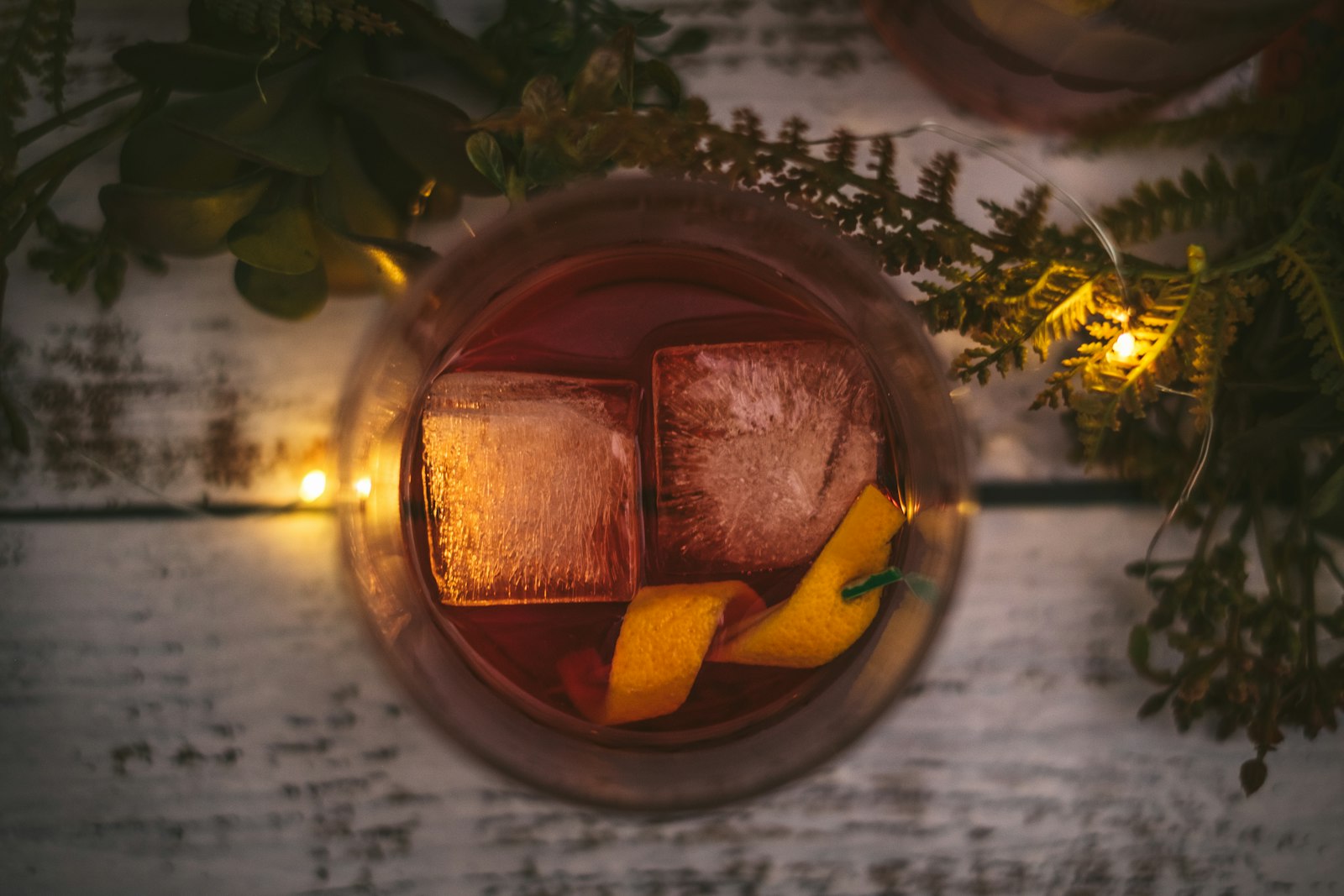 Warm gin and orange in a heatproof glass with an orange peel curl and cinnamon stick