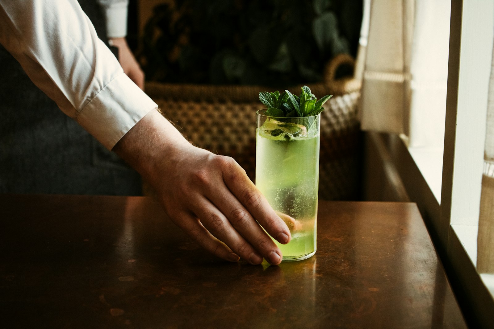 Warm rosemary gin in a heatproof glass with a fresh rosemary sprig
