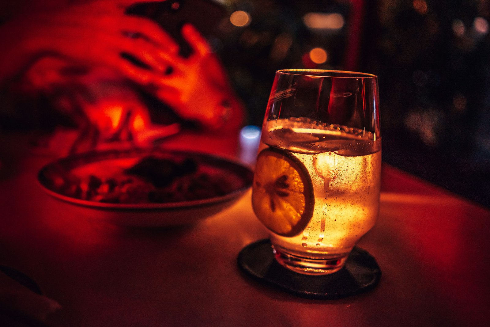 A creamy white cocktail in a coupe glass with a sugared and coconut rim