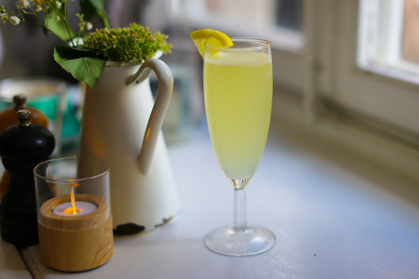 Festive Winter French 75 in a tall champagne flute with a long lemon twist