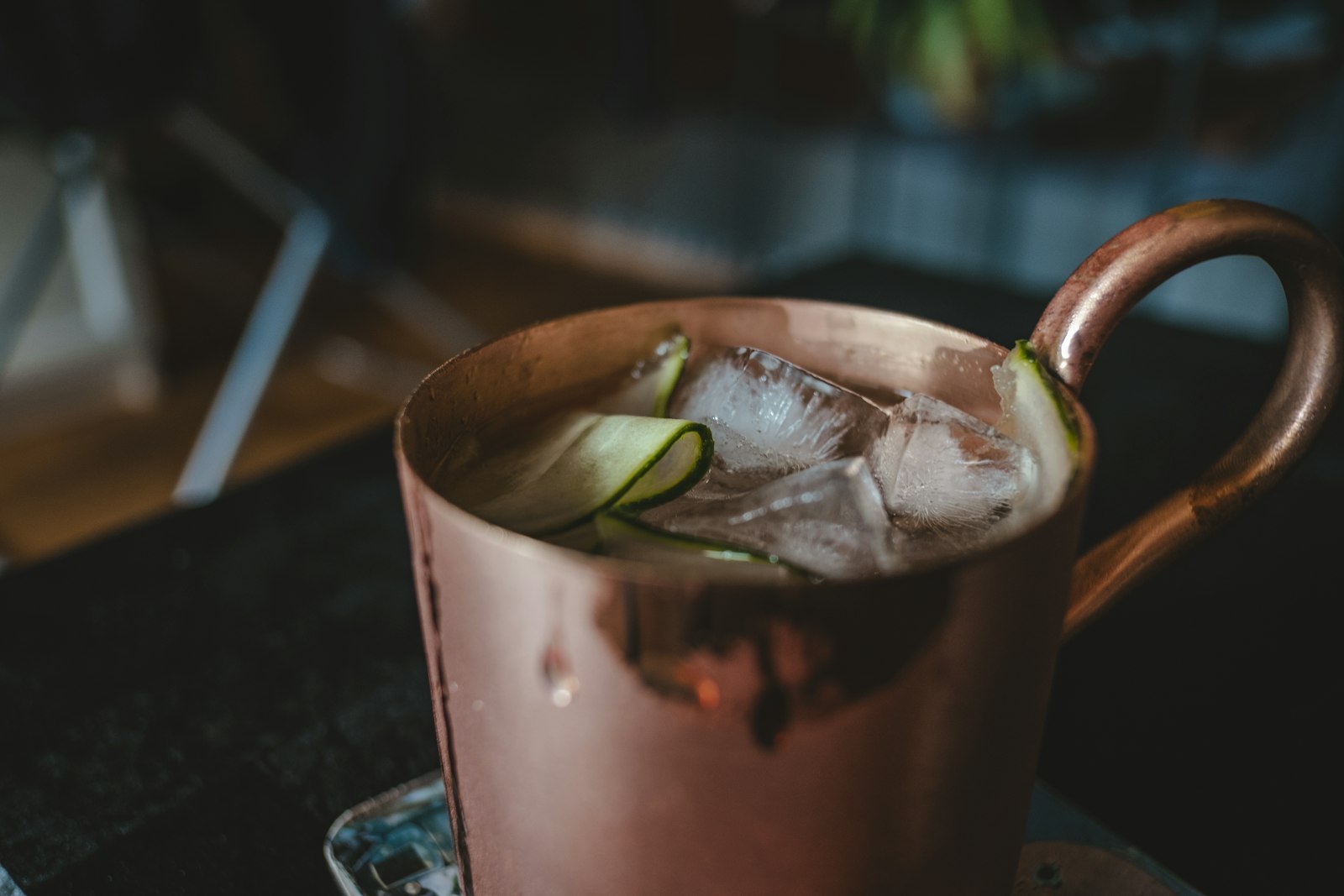 Winter Moscow Mule in a copper mug with cranberry juice, cinnamon stick and lime wheel