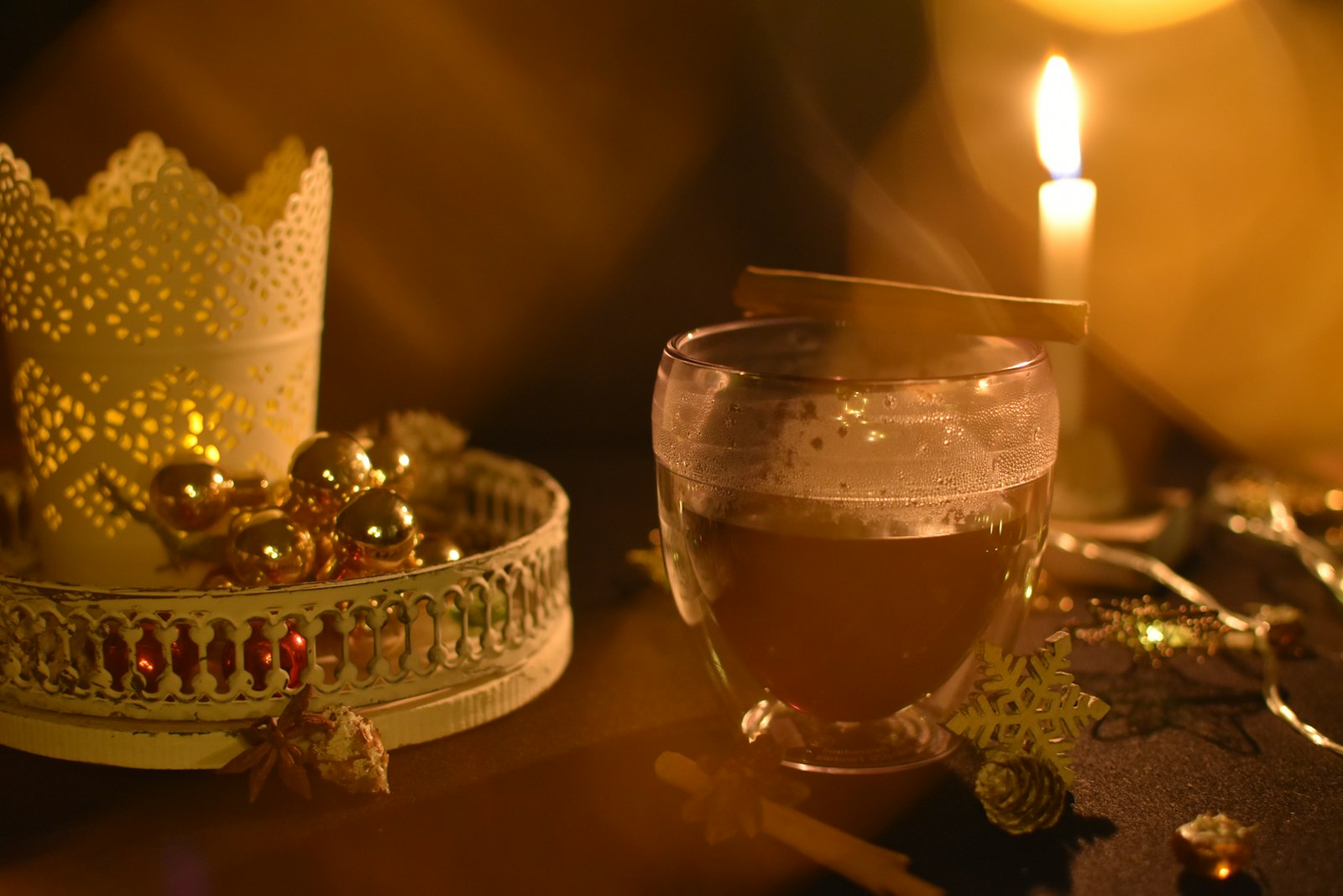 Warm winter rum punch in a mug with orange slices, lime slices and a cinnamon stick